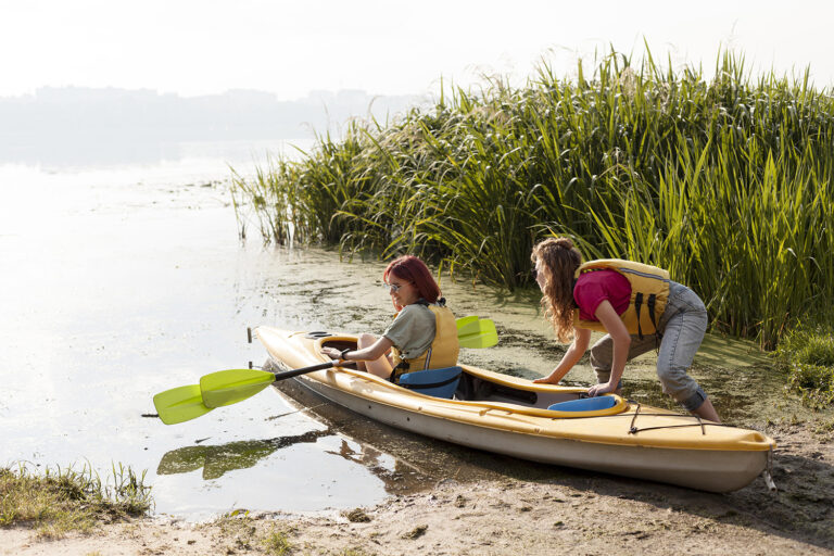 Women getting high performance kayak out of water