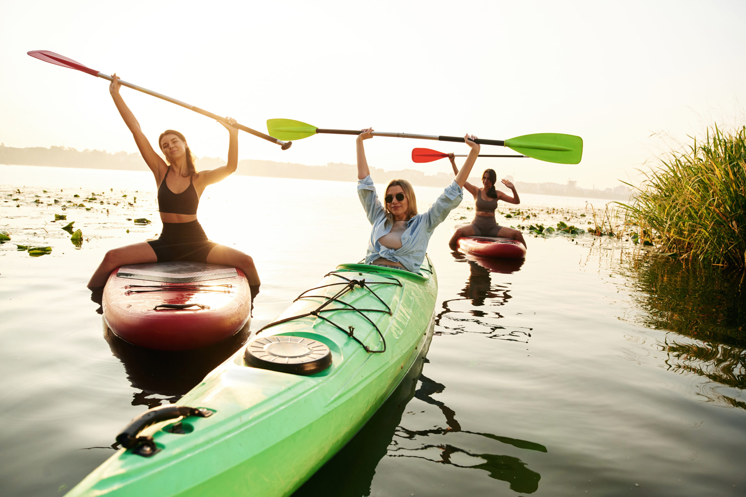 Friends celebrating on sup boards on the lake together
